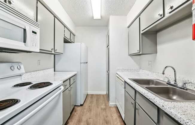 A kitchen with white appliances and cabinets.