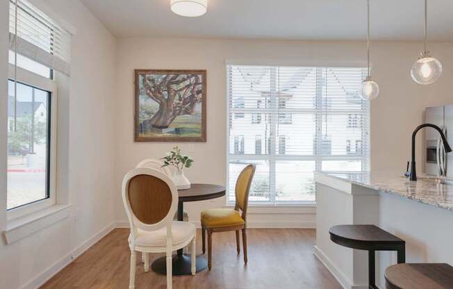 A dining area with a table and chairs.