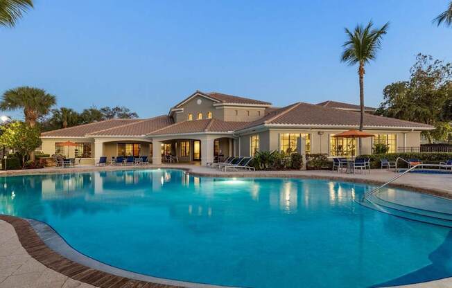 A large house with a pool in front.