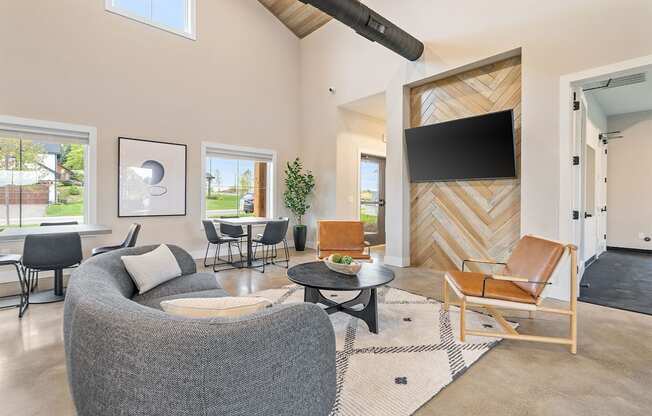 a living room with a couch and chairs and a tv