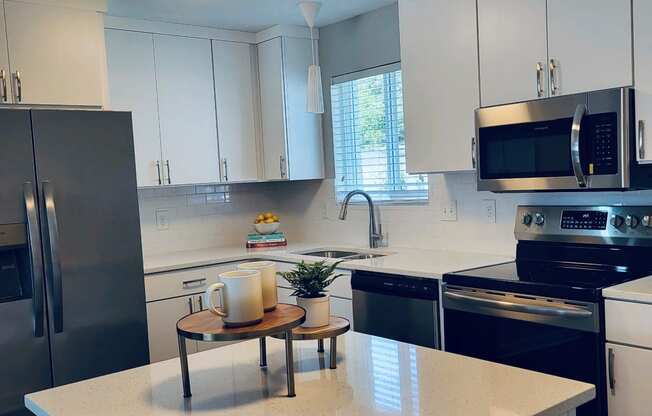 a kitchen with white cabinets and stainless steel appliances