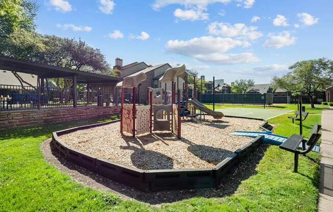 A playground with a sandbox and a slide.