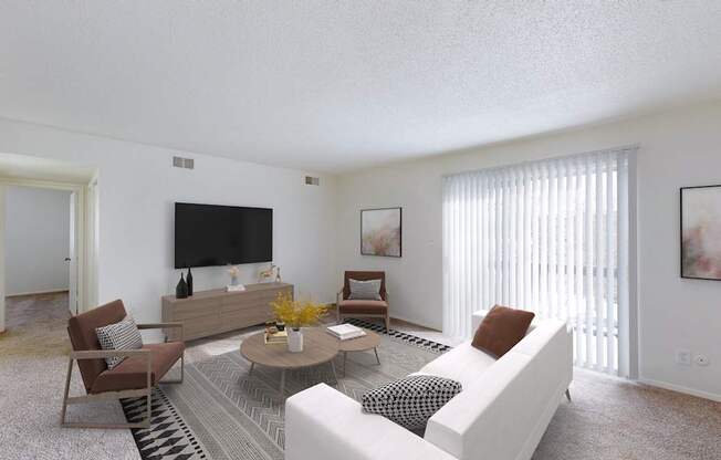 A living room with a white couch, a coffee table, and a flat screen TV.