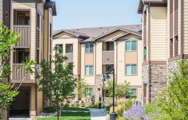an apartment building with a sidewalk and green grass
