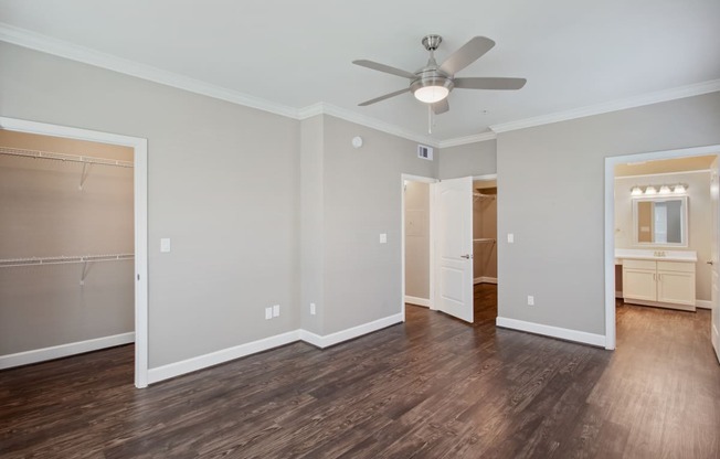 an empty living room with a ceiling fan and a closet