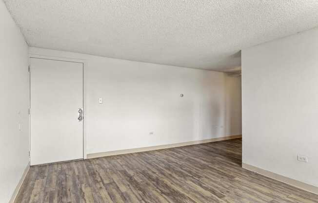 an empty living room with white walls and wood flooring
