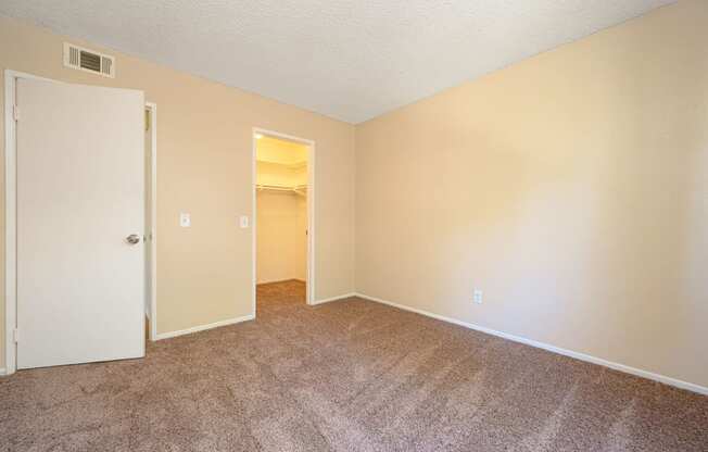 a bedroom with a carpeted floor and an open door at Oak Terrace Senior Apts, Hemet California