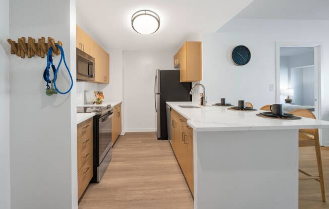 a kitchen with a white counter top and a black refrigerator