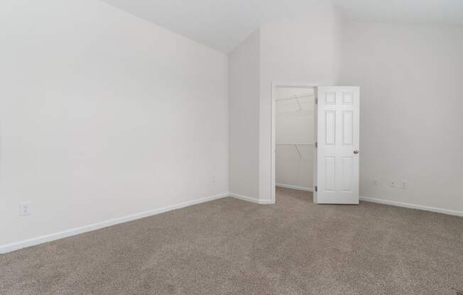 an empty room with a door to a closet