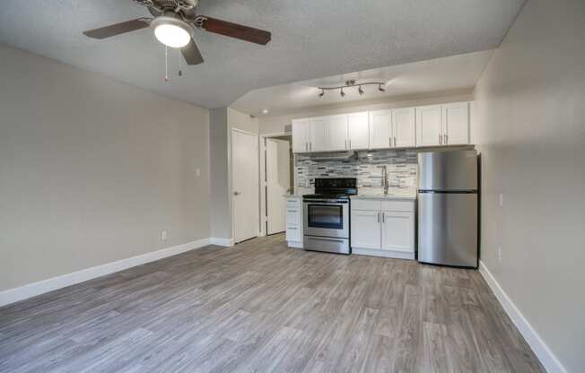 an open living room and kitchen with a ceiling fan