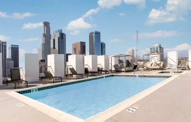 a pool on the roof of a building with a city in the background