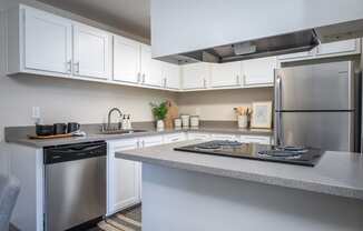 a kitchen with white cabinets and stainless steel appliances and a counter top