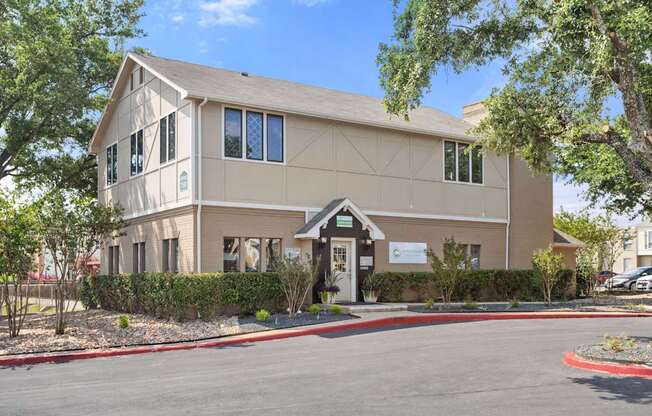 A beige building with a green signboard on the front.