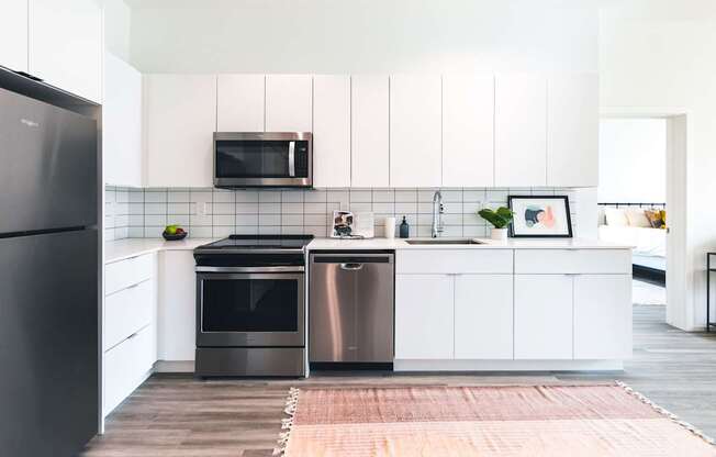 A modern kitchen with a black refrigerator and stainless steel appliances.