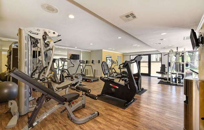A gym with a variety of equipment including treadmills, weights, and exercise machines.