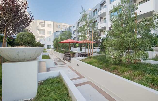 A white concrete pillar sits in the middle of a walkway at Woodley Sara Apartment, Van Nuys, CA, 91406