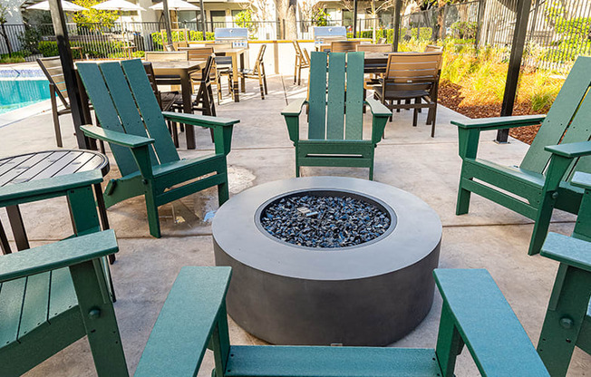 Pleasant Hill Apartments for Rent - Ellinwood - Firepit with Green Chairs and Shaded Cover