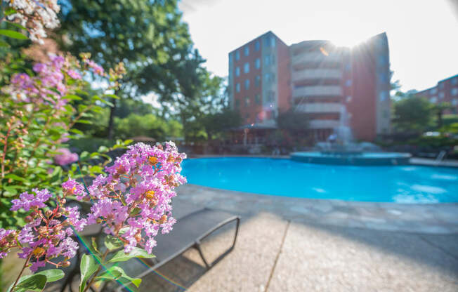 a swimming pool with a fountain and a bench in front of a building