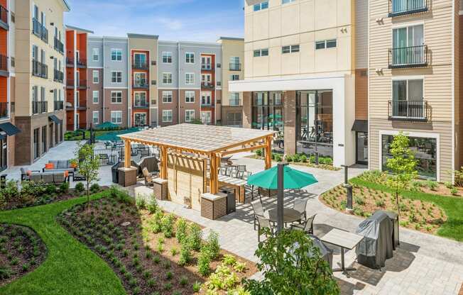 an outdoor patio area with tables and umbrellas in an apartment building