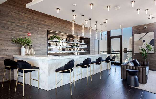 A modern bar with black chairs and a wooden wall.
