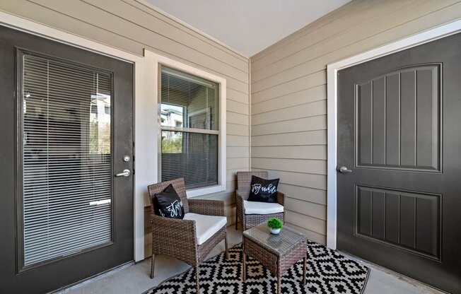 A patio with a chair and a table with a pillow on it.