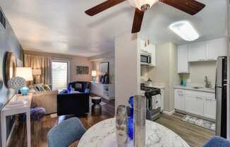 Large Living Room with Window, Hardwood Inspired Floor, View of Kitchen and White Granite Table