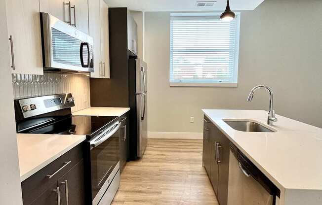 A kitchen with dark wood cabinets and stainless steel appliances.