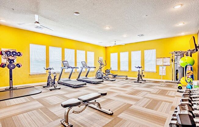 fitness center with cardio equipment and free weights at the flats at sundown apartments in north port florida