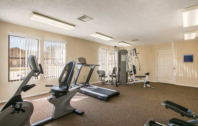 A well-equipped gym with treadmills, elliptical machines, and weights.