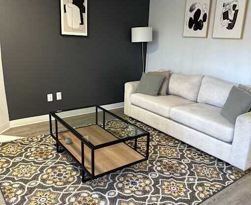 A living room with a white couch and a coffee table.