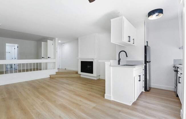 a renovated living room with a kitchen and a fireplace