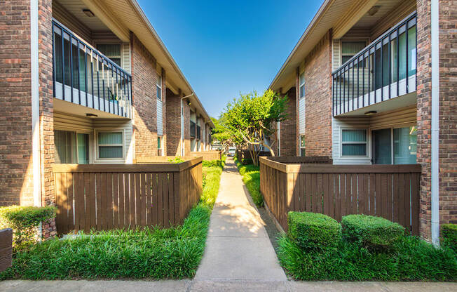 Apartment building exteriors showing patios, balconies and landscaping at Preston Park Apartments in the Far North Dallas neighborhood of Dallas, TX