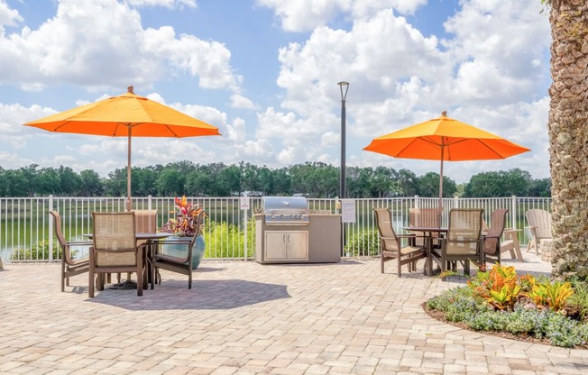 an outdoor patio with tables and umbrellas and a fire pit