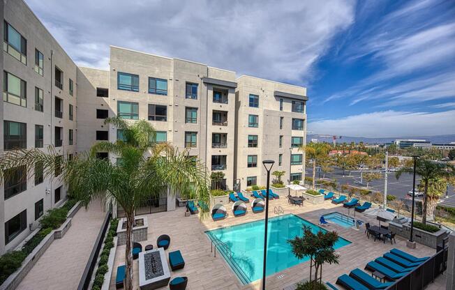 Expansive pool terrace with seating, palm trees, and a firetable that enhances the outdoor experience.
