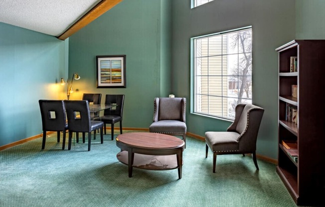 a living room with a table and chairs and a window