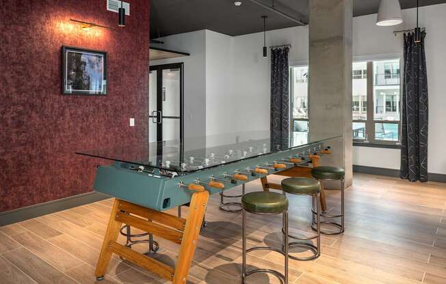 A bar with a green table and four stools.