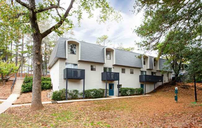 a white house with trees and a sidewalk at Elea Apartments in Marietta, GA