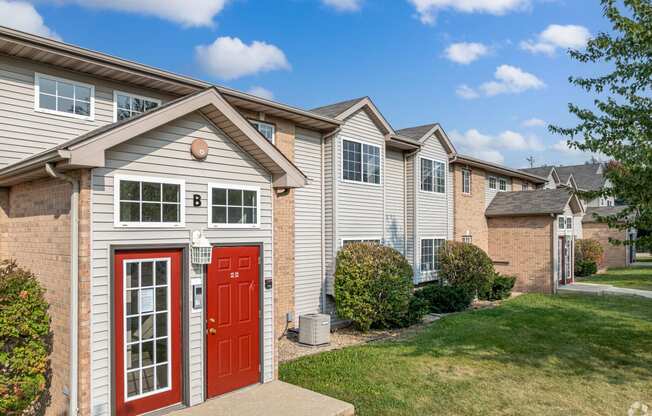 a home with a red door on the side of a street