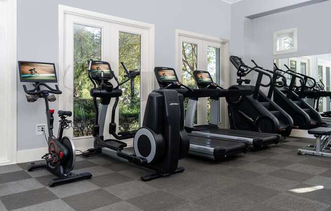 A row of exercise equipment is lined up in a room.