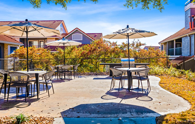 an outdoor patio with tables and umbrellas
