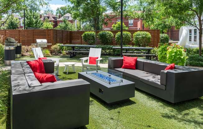 a backyard patio with couches and chairs and a fire pit at Grand Flats, St. Louis, MO