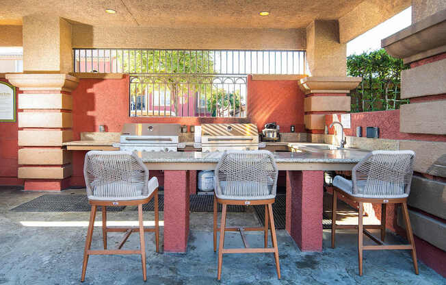 A table with four chairs is in front of a red wall.