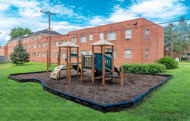 a playground in front of a brick building at Hamilton Manor Apartments, Hyattsville, 20782