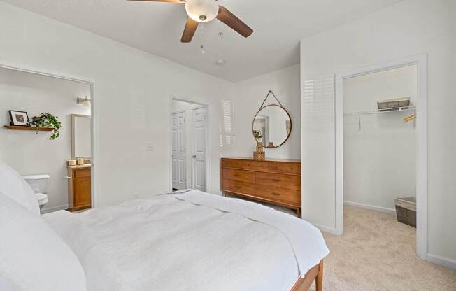 A bedroom with a large bed and a ceiling fan.