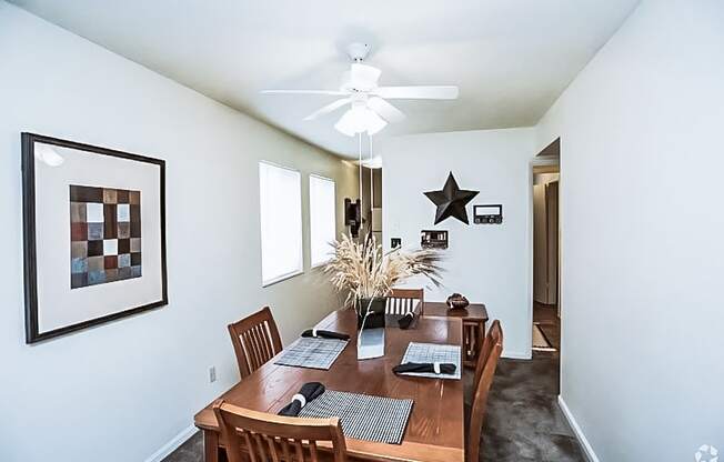 a dining room with a wooden table and a ceiling fan