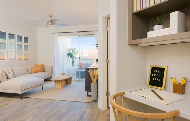 a living room with a white couch and a desk