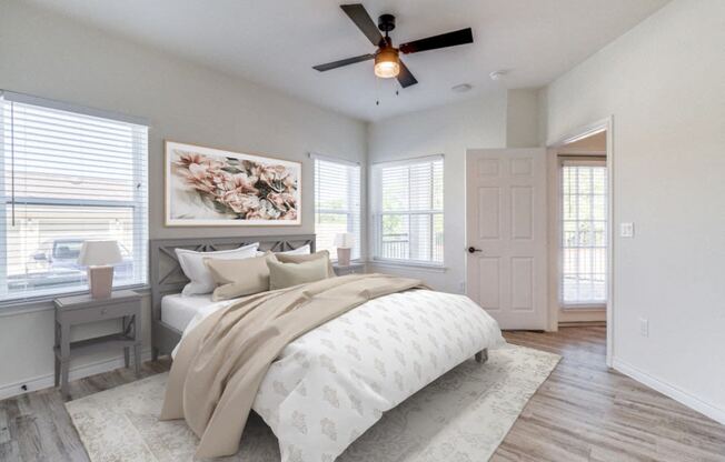 an empty bedroom with a bed and a ceiling fan