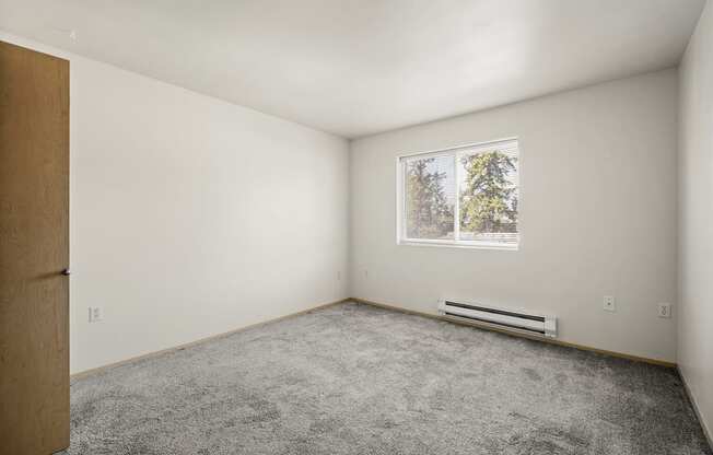 a bedroom with white walls and carpet at Mill Pond Apartments, Washington