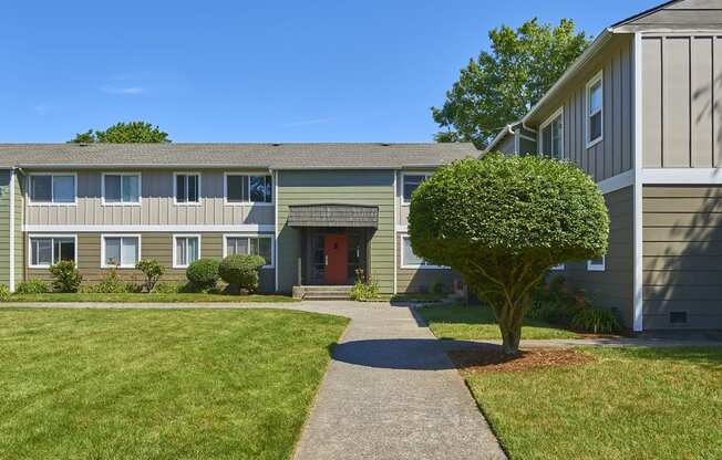 Exterior grounds with paved pathway leading through large grass area to homes.at Woodhaven, Everett, Washington