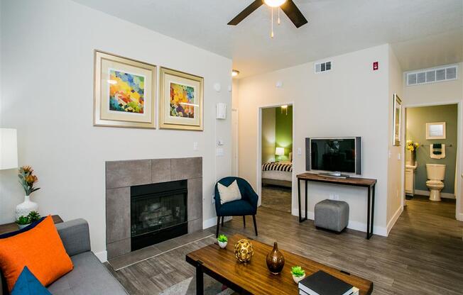 a living room with a fireplace and a ceiling fan